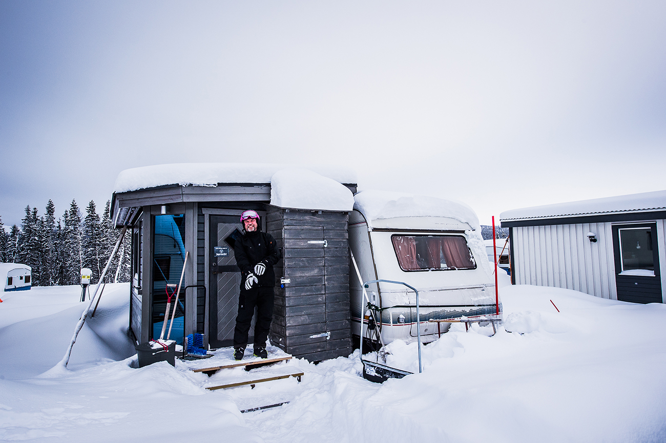 Bild på en man vid ett snötäckt campingområde.
