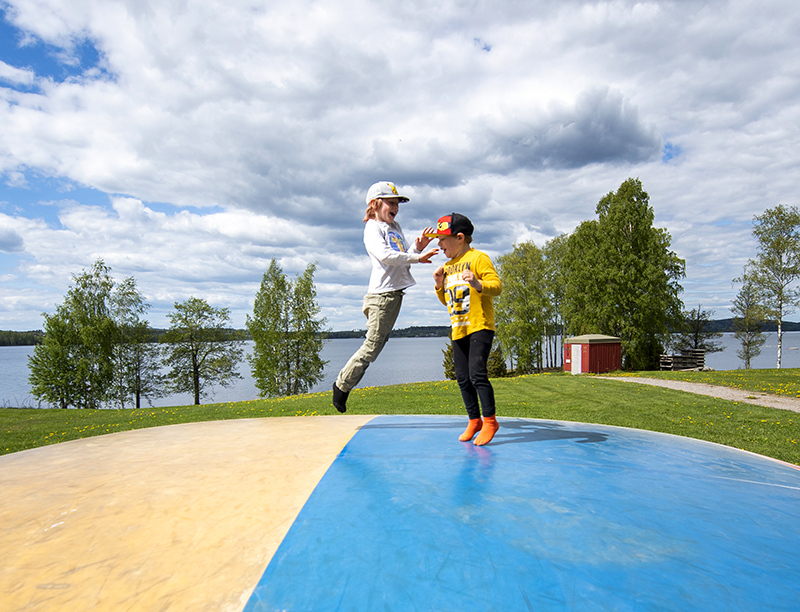 Barn hoppar och skrattar på den stora hoppkudden vid Frykenbaden
