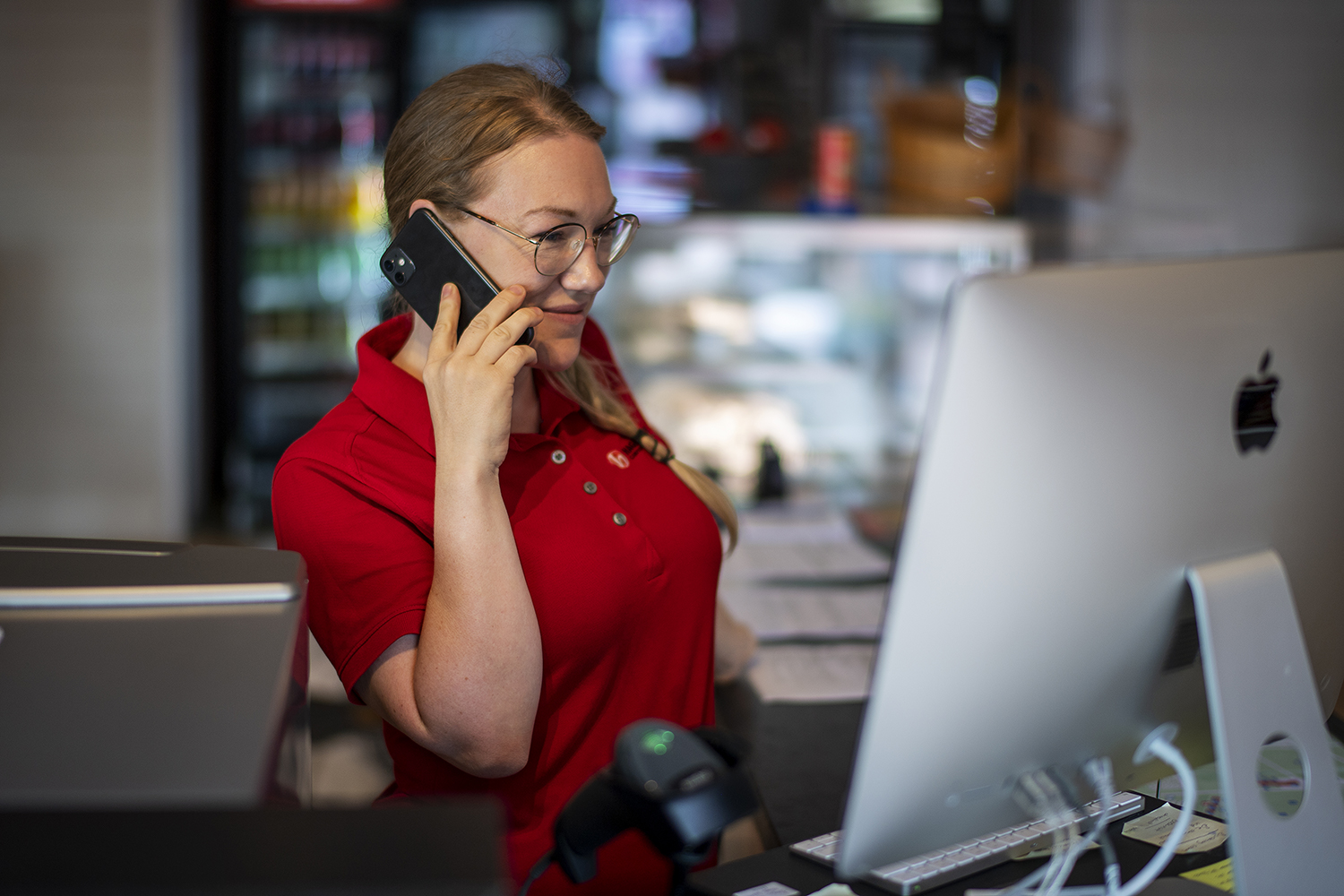 Tove i receptionen hjälper en gäst via telefon.